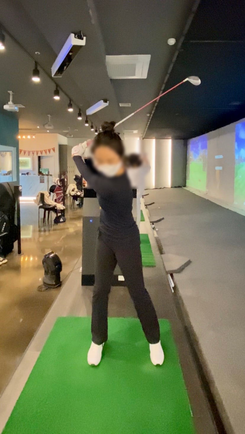 골프 프로가 입문자의 스윙 자세를 1대1로 교정하는 모습